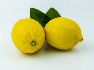 Natural Lemon fruits with green leaves isolated on white background.