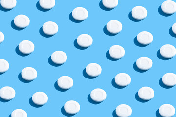 Pattern of pieces of solid soap on a blue background with trendy sunlight. Wash your hands. Soap against bacteria and viruses. Compliance with hygiene and sterility to combat coronavirus.