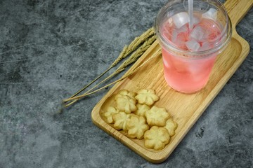 Butter cookies with milk and tasty and delicious beverages are placed on wooden trays to serve consumers at leisure and in need of desserts, in order to relax while eating.