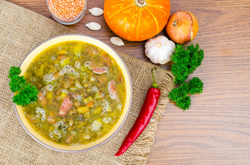 Soup from pumpkin, lentil and sausage. Photo