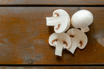 Fresh champignon mushrooms on wooden table, closeup. Space for text