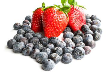 Strawberries with blueberries on white isolate. Blueberries in water spray.