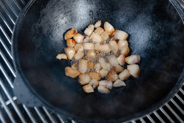 Pieces of lamb with onion are fried in boiling oil on the fire. As a stage in the preparation of...