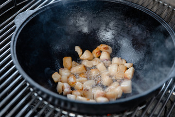 Pieces of lamb with onion are fried in boiling oil on the fire. As a stage in the preparation of...