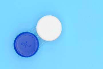 Contact lens case on blue pastel background .