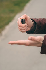 take your hands using a hand wash gel dispenser against a new coronavirus or coronavirus disease (Covid-19) on a street in the city. The concept of antiseptics, hygiene and health