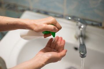 Prevention of the coronavirus pandemic: an adult woman squeezes antibacterial soap on her hands - 341430887