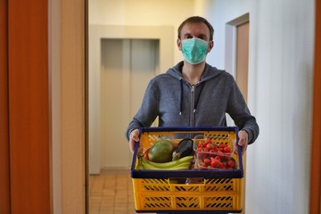 Lebensmittellieferung von Obst und Gemüse in Corona Krise vor die Haustür mit Schutzmaske wegen...
