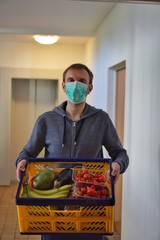 Lebensmittellieferung von Obst und Gemüse in Corona Krise vor die Haustür mit Schutzmaske wegen...