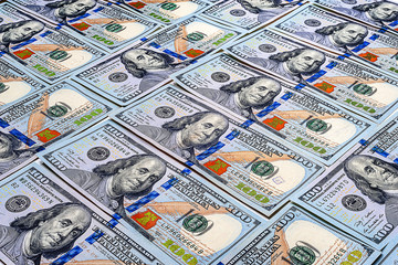 One hundred US dollars background. A large number of bills. A pile of American dollars banknotes....