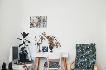 workplace in the artist's studio interior with painting, computer and table in light tones
