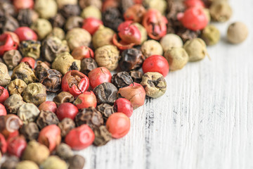 mixed peppercorns on a wooden board