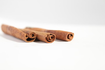 three sticks of cinnamon or Cassia lie on a white background