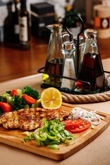 Authentic greek cuisine main course presentable plating on casual dine in background. Traditional greek chicken chop with fresh steamed vegetables photography best for magazine concept.