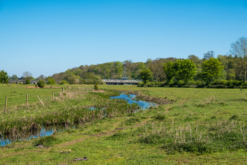 Countryside landscape with distant railway bridge