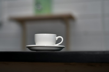 White cup of espresso coffee on a dark blurred background. Selective focus.