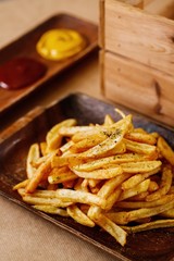 Classic potato fries side dish on wooden tray amazing appetizer plating. Mediterranean cuisine photography for magazine or online delivery menu concept.