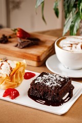 Freshly baked bread with variety of toppings on a wooden tray in casual dine in table background with coffee latte. And cheese cubes. Authentic Mediterranean cuisine photography concept.