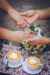 hands of husband and wife and two cups of coffee