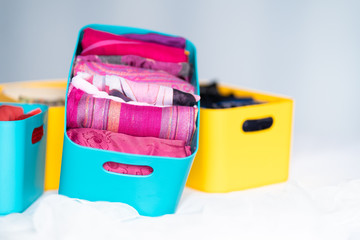 Man  brings wardrobe order puts everything on its place hides things in boxes. Closet organized....