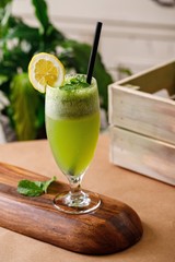 Healthy lemon mint fresh juice on elegant glassware in a wooden background. Authentic cuisine beverage options on menu.