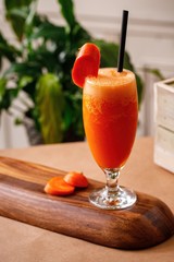 Healthy carrot fresh juice on elegant glassware in a wooden background. Authentic Mediterranean cuisine beverage options on menu.