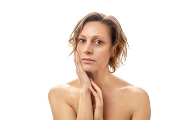 Obraz premium Beautiful young woman with a short haircut is touching her face skin. Clean skin. Naked to the shoulders posing. isolated white background.