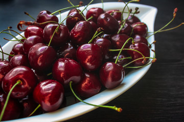Kirschen in weißer Schale auf dunklem Untergrund