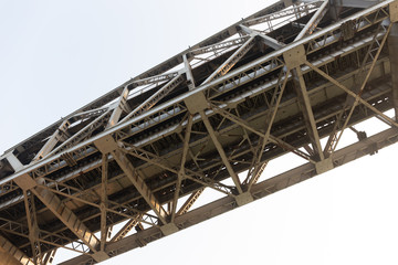 Close up shot of a portion of the indian railway bridge of Varanasi on the holy river Ganges. View from below during a boat ride on the river at dawn.