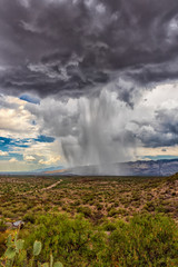 thunderhead cloud produces rain shower over semi-desert grassland prairie