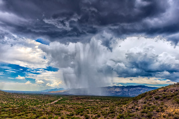 thunderhead cloud produces rain shower over semi-desert grassland prairie