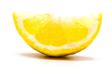 Close up on a slice of fresh lemon wedge isolated