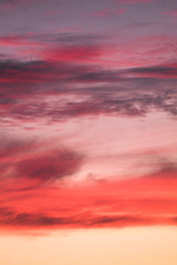 Summer sunset with pink-orange sky with clouds.