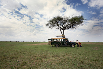 Fototapeta premium Tourists enjoying food in the mid of game drive in Masai Mara National Reserve
