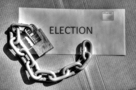 Lock and chain resting on an envelope for vote by mail ballot for election security.  