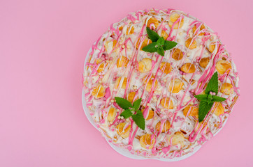 Homemade cream cake decorated with eclairs. Photo