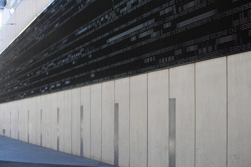 Fototapeta premium Commercial building with a large outdoor digital wall display LED screen with numerals, characters and glitches running across the screen. Sound speakers