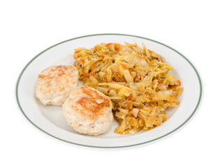 Plate with meat patties and stewed cabbage isolated on white background.