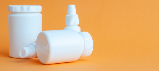 Close-up of two portable plastic bottles with disinfectant antiseptic gel and one bottle of pills...
