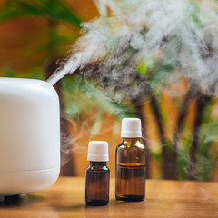 Natural Essential Oil Bottles and Aroma Therapy Diffuser on a Wooden Table - obrazy, fototapety, plakaty