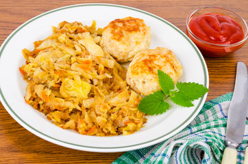 Stewed cabbage, meat cutlets, spices, salt on wooden table.