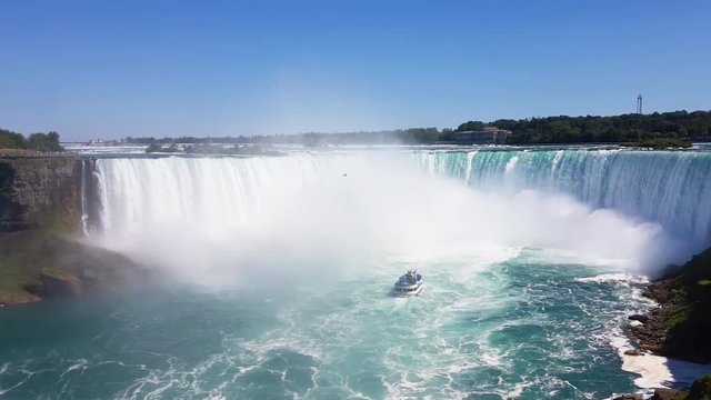 The famous waterfall of Niagara Falls, a popular place among tourists from all over the world. View from the Canada. In the image waterfall and boats can be seen at the same time.
