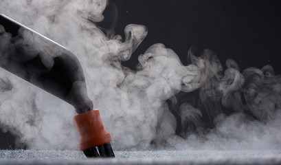 Steam close-up. Steam carpet cleaning on a grey background. Home cleaning.