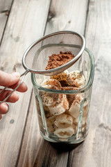 Ingredients for smoothies. Bananas, chia seeds and cocoa powder in a blender on a white background.