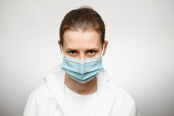 portrait of woman wearing in face mask, looking at camera on white background.
