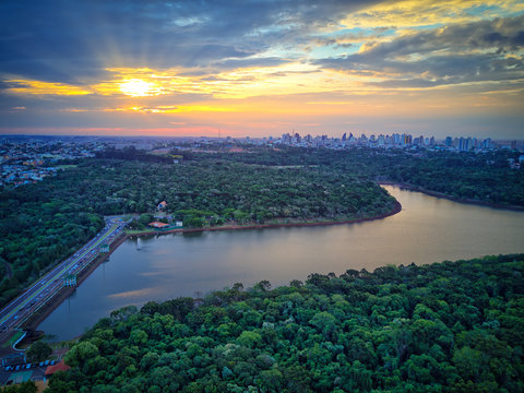 Vis&atilde;o a&eacute;rea da cidade de Cascavel, Paran&aacute; e lago municipal. Imagem feita por drone. Maravilhoso p&ocirc;r do sol e natureza.