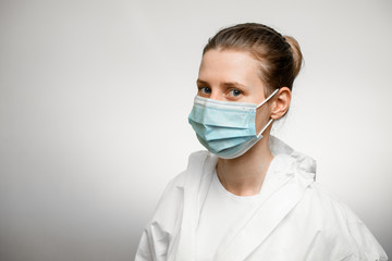 Young female doctor wearing protective suit and medical mask.