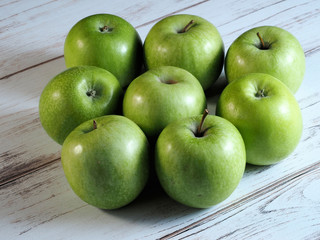 Juicy green apples on wooden background