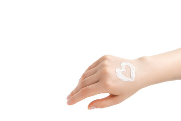 Hand cream on a woman's hand, heart shape. Young woman applying hand cream on white background. Palm facing down.