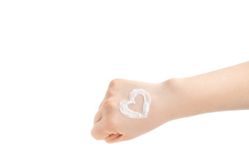 Woman arm with cream heart shape. Young woman applying hand cream on the fist, on white background.